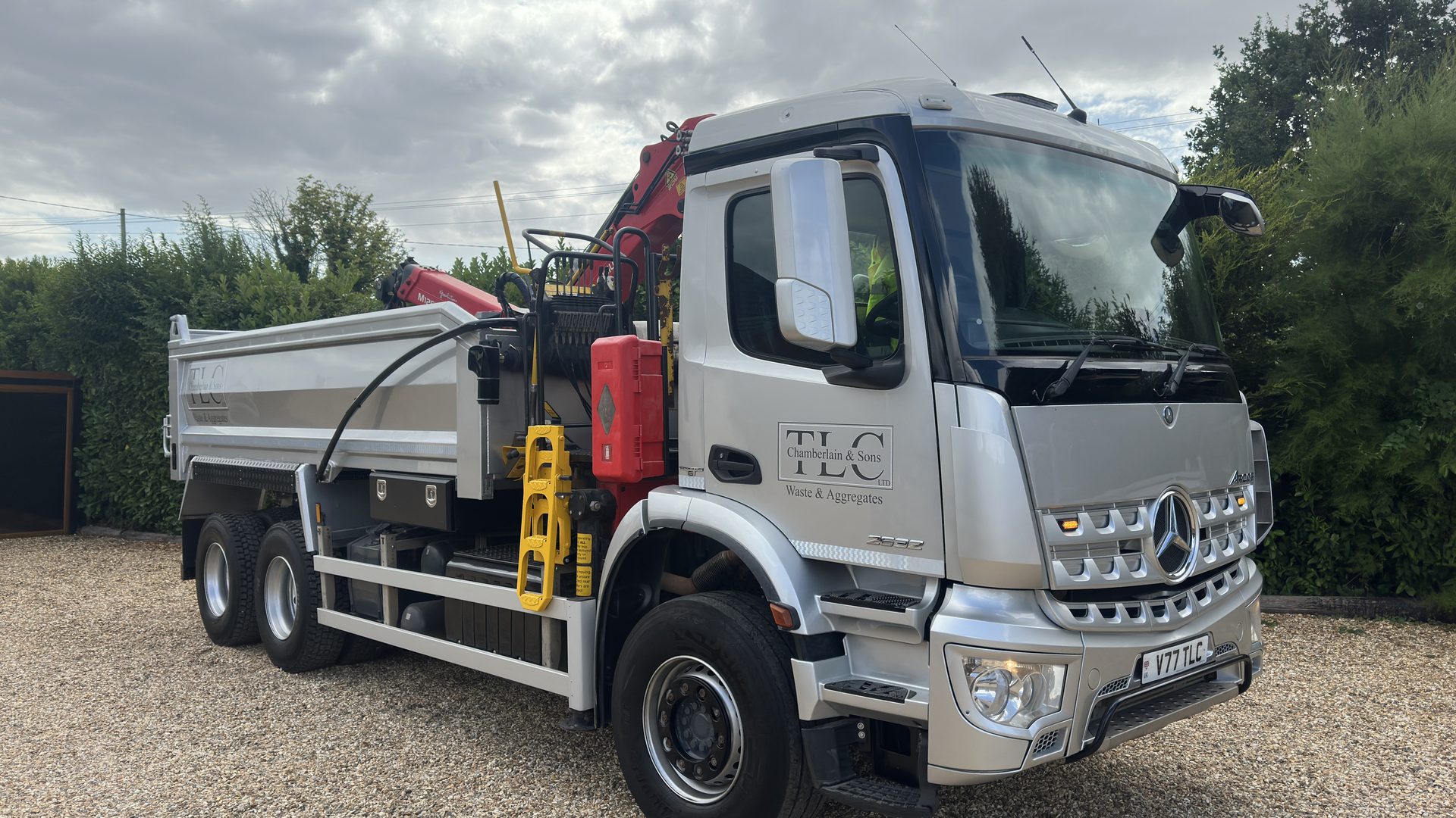 Side view of the grab lorry showing the tipper body and folded grab crane
